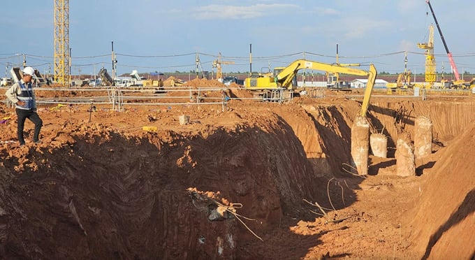 Công nhân đào đất để xây dựng móng nhà ga