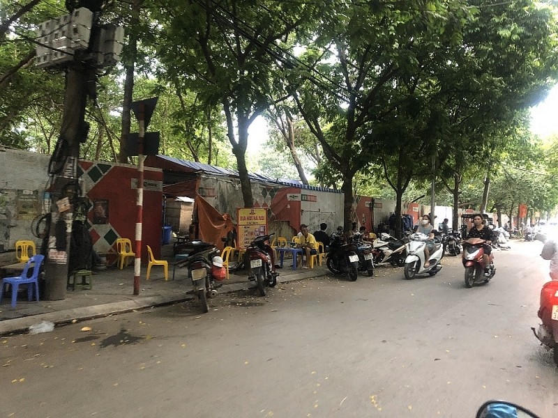 Sau hơn 10 năm, dự án vẫn “treo” chưa thực hiện, hiện trạng khu đất được rào tôn, xung quanh dự án bị người dân chiếm dụng làm quán bia, bán hàng... Ảnh: Bảo Xây dựng &nbsp;