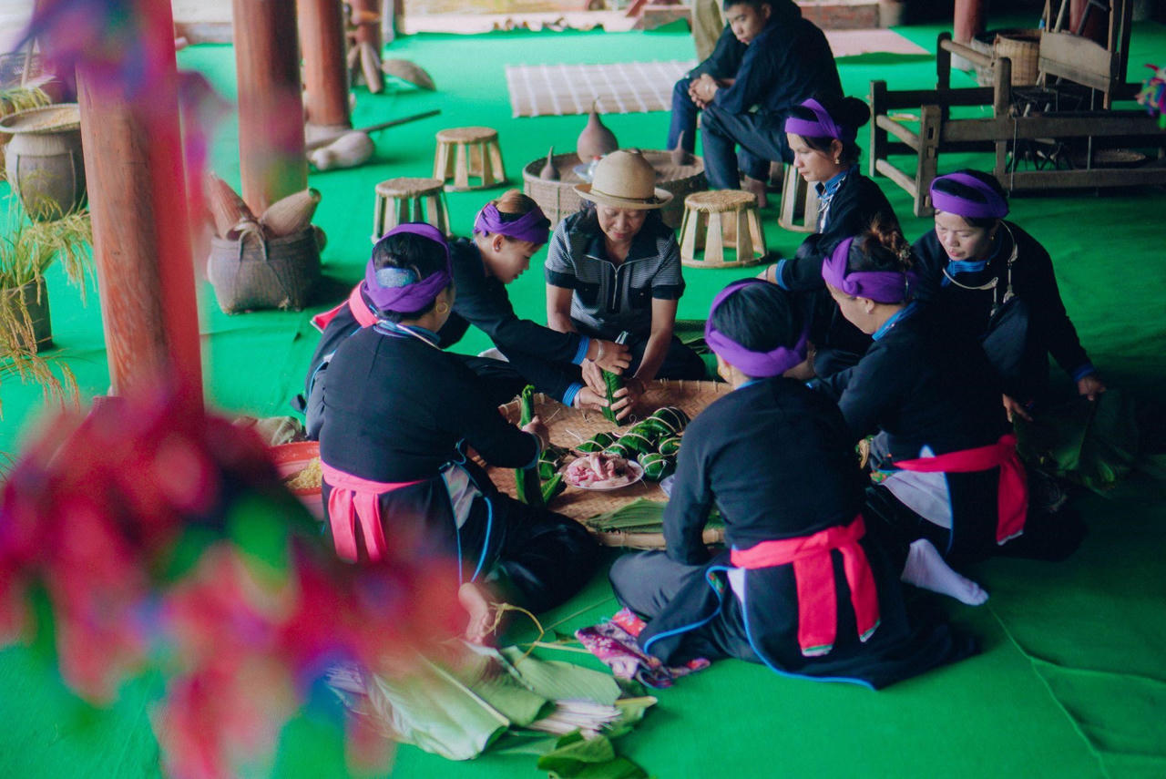 Du khách trải nghiệm làm bánh chưng gù tại khu vực Chợ quê Sun World Fansipan Legend. &nbsp;