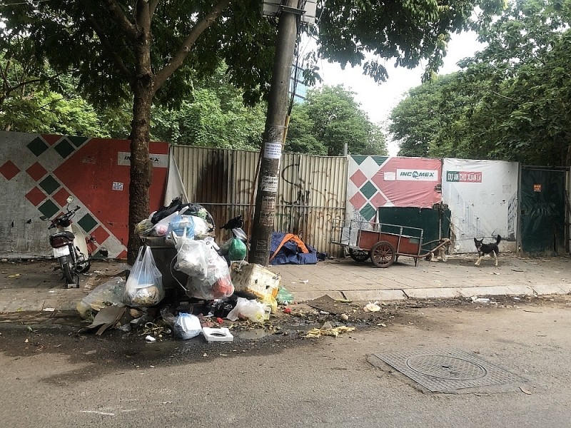 Hiện tại, ngay trước cổng vào dự án thành nơi tập kết rác thải, dẫn đến cảnh tượng mất vệ sinh, ảnh hưởng đến đời sống cư dân xung quanh. Ảnh: Báo Xây dựng &nbsp;