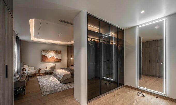 Phòng master có vách ngăn duyên dáng là tủ đồ vách kính đen, bảo vệ sự riêng tư cho gia chủ. Ảnh: NhaF