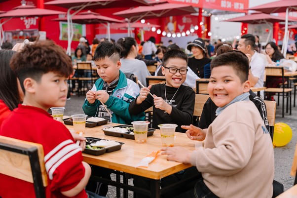 Nhóm khách nhí tham quan Hội chợ Mùa Xuân và thưởng thức ẩm thực tại khu Food Court.