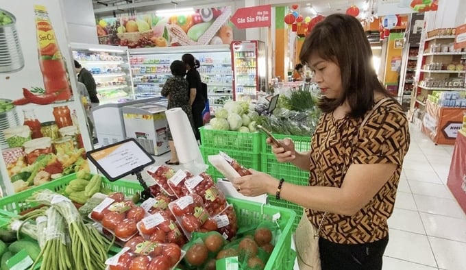 Người tiêu dùng quét mã truy xuất nguồn gốc sản phẩm khi mua hàng tại siêu thị.