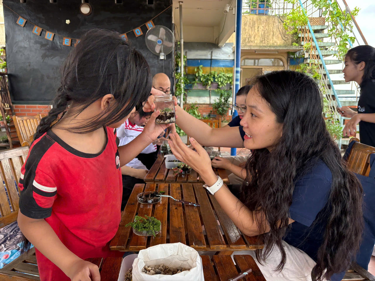 Tại trung tâm Tổ chức Trẻ em Rồng Xanh tại Hà Nội, tình nguyện viên CLD Việt Nam đồng hành cùng các em nhỏ trong hoạt động STEM kiến tạo trồng cây sinh thái terrarium, phổ cập kiến thức cơ bản về thực vật, đất và hệ sinh thái