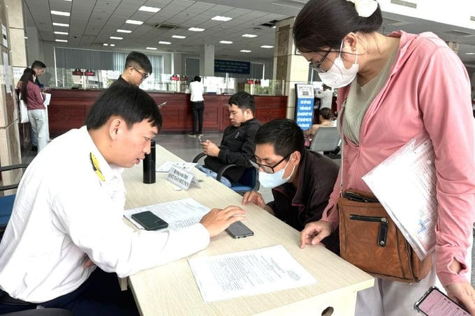 Công chức Thuế Tp. HCM hướng dẫn người nộp thuế dùng ứng dụng Etax Mobile. Ảnh Đỗ Doãn