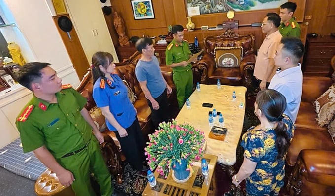 Công an thi hành lệnh khám xét nơi làm việc của ông Cao Tiến Đoan (áo cam) - Ảnh: Công an Thanh Hóa.