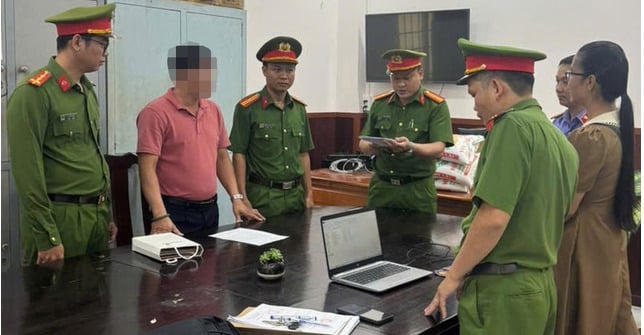 Bị can Trần Văn Trạng (áo đỏ) nghe cơ quan công an tống đạt các quyết định khởi tố, bắt tạm giam ẢNH: CÔNG AN CUNG CẤP.